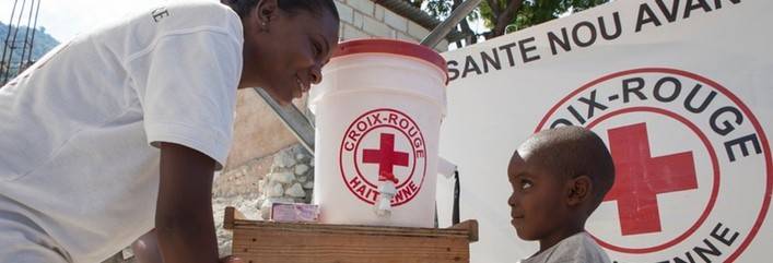 November 15, 2012. Port-au-Prince, Haiti. Antoine Ordea (L) of the American Red Cross and Peterson Pierrot, 4, wash hands in Campeche, Port-au-Prince. Photo by Talia Frenkel/American Red Cross