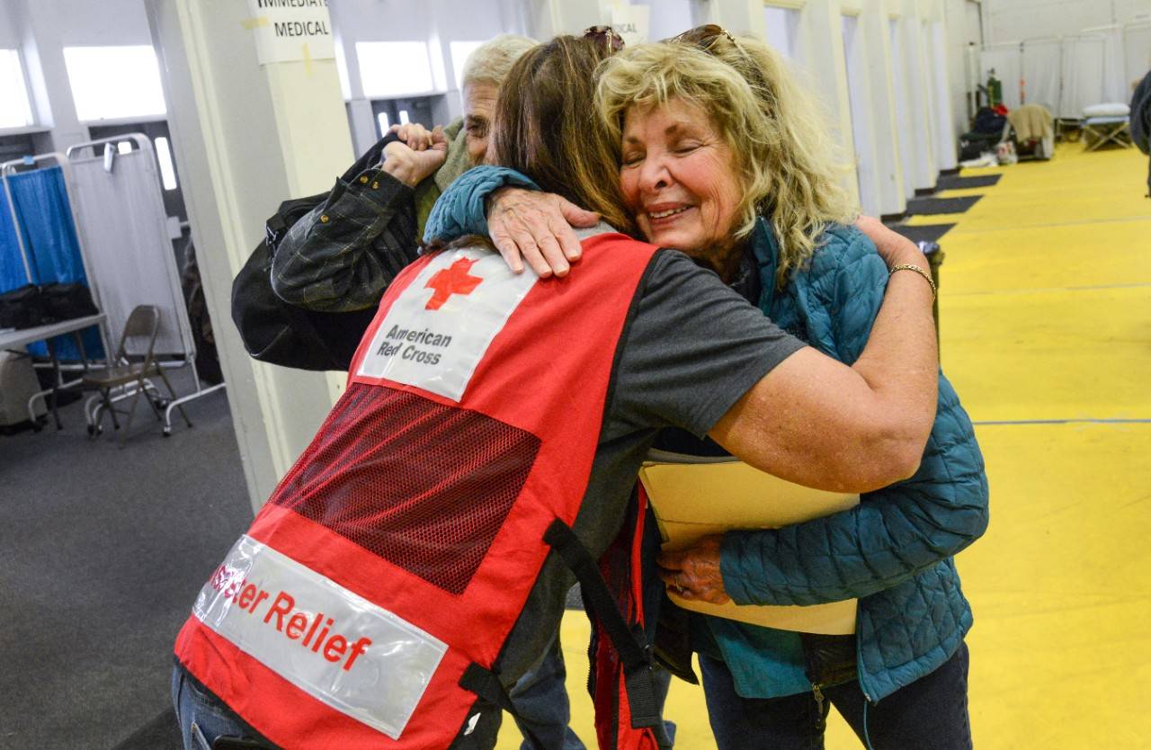 November 12, 2018. Gridley, California.
Joy and tears as Diane Papedo finds her brother, Phil Mazores and are reunited at the at the Butte County Fairground Red Cross shelter. 
“You’re here, the Red Cross is here, and we need you! Thank you for keeping him safe!” Diane and Phil talk with Red Cross volunteer Vicki Eichstaedt as they prepare to leave the shelter.
Photo by Daniel Cima/American Red Cross