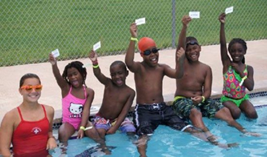 Group of kids and Red Cross volunteer at a swim class