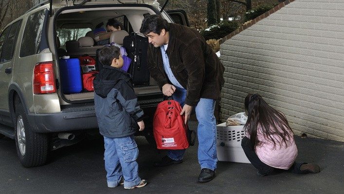 man and young boy packing car