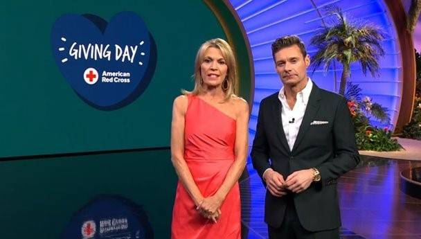 Vanna White and Ryan Seacrest on Wheel of Fortune with a heart-shaped American Red Cross Giving Day logo