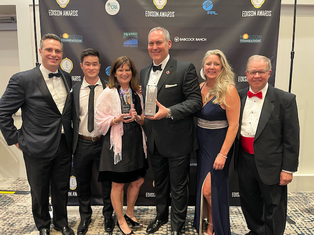 The Code4Good team, dressed in formal clothes, accepts Edison Silver Award.