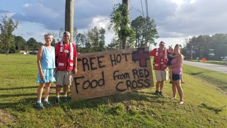 Joe (a la izquierda) contando sobre las comidas de la Cruz Roja Americana. 