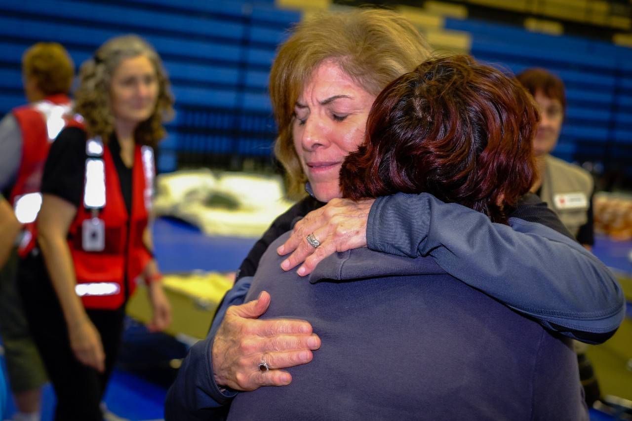 August 30, 2017. Delco Center Shelter, Austin, Texas. Gail McGovern embraces a resident at a shelter. Photo by Chuck Haupt for the American Red Cross