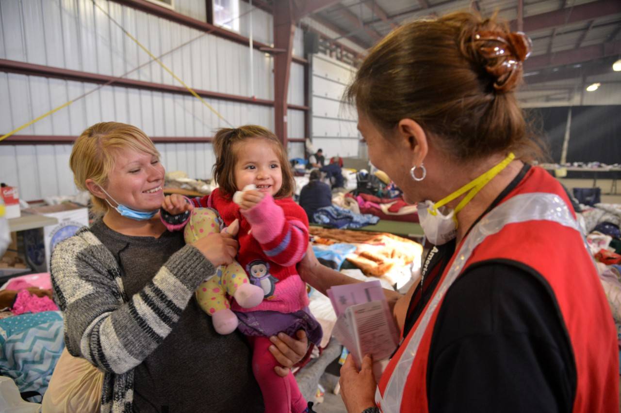 December 8, 2017. Ventura, California.Ashley Vargas, age 18months, charms everyone she meets in the Ventura County Fairgrounds shelter. Red Cross disaster volunteer Vicki Eichstaedt was no exception, as she enjoyed talking with Ashley and her mother, Crystal Serrano.Photo by: Dermot Tatlow/American Red Cross