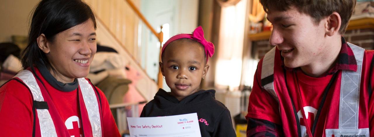 March 14, 2018 Private home. New York, New York.Pictured: ARC volunteers Shanley Arizona and Harry McSweeney with Amira SmithTwo-year-old Amira Smith may not be able to read that Home Fire Safety Checklist she's holding, but American Red Cross volunteers Shanley Arizona and Harry McSweeney will make sure her mother, Deasia Copeland, knows exactly what to do in case of a fire in the home. They just installed new smoke alarms in the home, at no charge to the family. The free smoke alarms and fire safety education are part of "Sound the Alarm," an effort to prevent fatalities from home fires.Photo by Marko Kokic for the American Red Cross