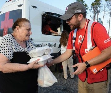 Volunteer in emergency response vehicle hands out meals
