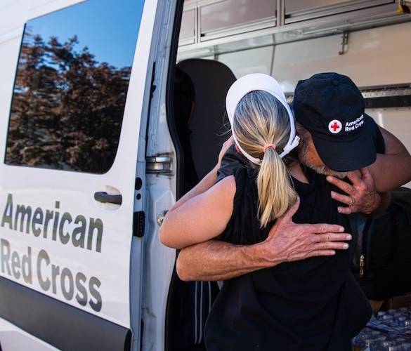 October 2, 2024. Hendersonville, North Carolina.
Hendersonville, North Carolina, resident Gretchen Tritt hugs Red Cross volunteer Neil Howard, whose team delivered 1,000 meals at East Henderson High School to people impacted by Hurricane Helene. Tritt was so inspired by the amount of generosity from organizations like the Red Cross, she said she wants to volunteer. “My whole life, I’ve been the first person there when a disaster happens. I think my gift is service.”
Photo by Danielle Desnoyers/American Red Cross


