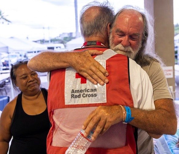 Red Cross volunteer shaking clients hand in shelther
