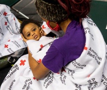 Mother holds child as he receives vaccination