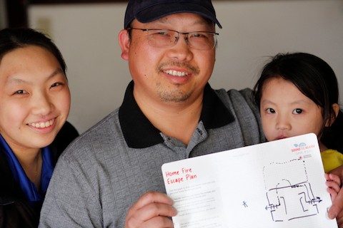 Family holding Home Fire Escape Plan handout