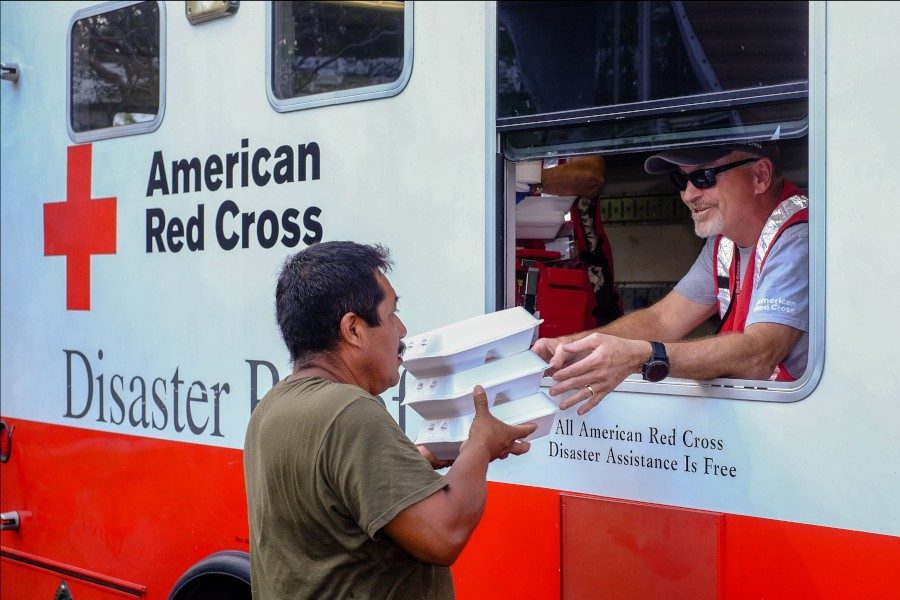 A Red Cross volunteer gives free hot food to a person affected by a disaster