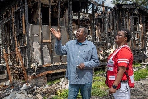 A homeowner meets with a Red Cross volunteer after a home fire