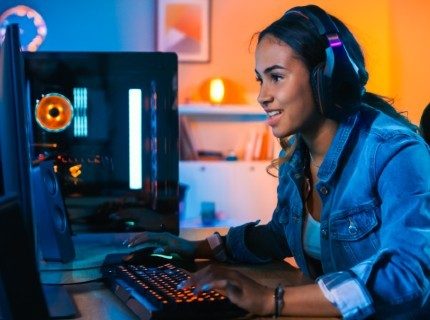 A young woman plays a game on her PC