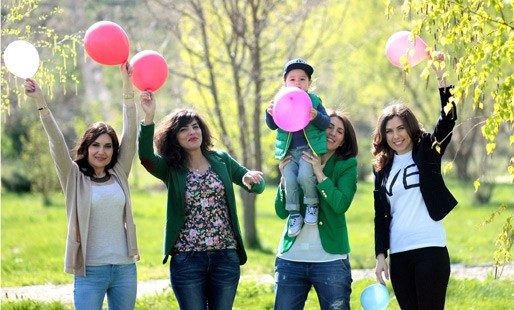 Family standing outside holding balloons