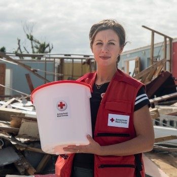 A Red Cross phlebotomist holds a note reading Thank You