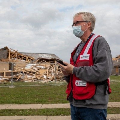 A Red Cross volunteer surveying the disaster damage.