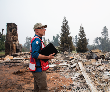 A Red Cross volunteer helps a disaster relief worker back a van into a parking spot