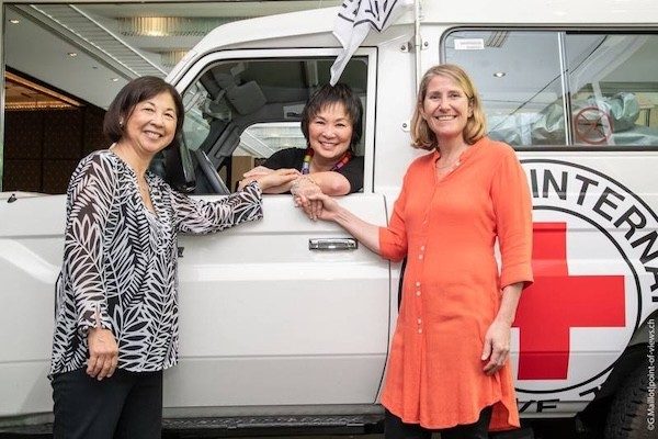 Josie Tong, a Taiwanese woman with short brown hair, sits in a Red Cross international vehicle.