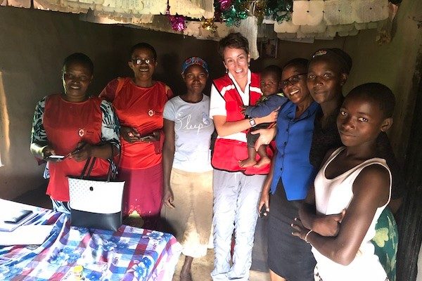 Sara Horein, a woman with short, brown hair, stands with a group of Kenyan women