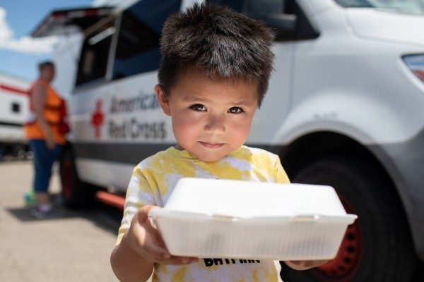 A child receives a hot meal from the Red Cross