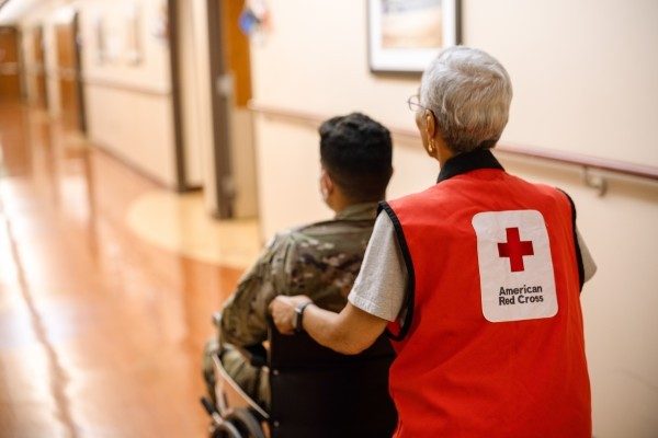 Red Cross volunteer assists a military member