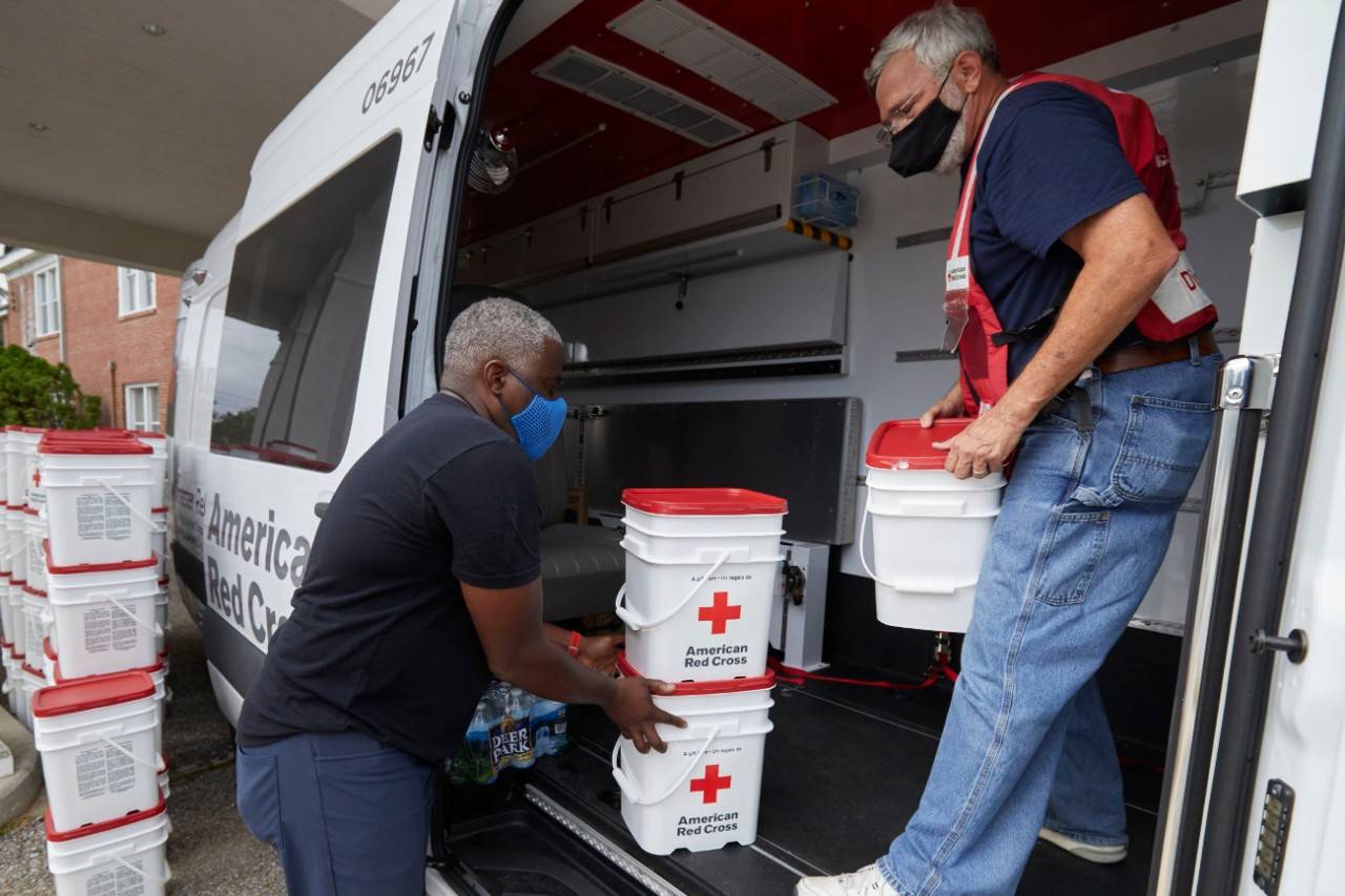 September 22, 2020. Pensacola, Florida.
American Red Cross Regional Executive Gerald Thomas  (on the left in the image) first interaction with the American Red Cross was learning that his oldest son had been born. He was in the Marine Corps and received a Red Cross message delivering the happy news. Later in life, he provided project management and strategic planning for the Service to the Armed Forces team at the Red Cross and then assumed the role of Regional Executive two and a half years ago. Throughout the years, his favorite part of his Red Cross experience has always been,  being a part of the community by working with partners and helping those with the most need and sharing what the Red Cross can do.  On September 22, 2020 at the Friendship Missionary Baptist Church, Gerald is helping run the distribution of emergency supplies and meals for the community of Brownsville, alongside Reverend May. This is the first event of many with this particular group of fellow humanitarians from a church that had been serving this community for more than 90 years.  This partnership is really emblematic of what the Red Cross can do in the community; how we can connect to high-performing partners that have reach into communities and places where we might not have connections but can show us the way. And then we can bring in our services to help them do their work also. I think this is a great example of that. 
Photo by Jaka Vin ek/American Red Cross