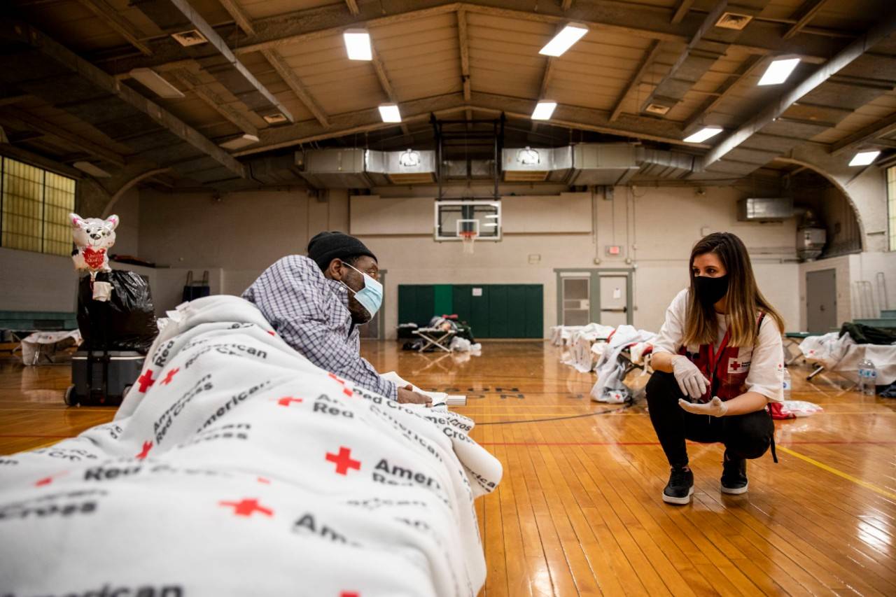 February 19, 2021. Houston, Texas.
American Red Cross volunteer Jessica Farias Zanette speaks with L.A. Tyner who is staying at a Red Cross shelter. A winter storm has left millions of Texas residents without electricity and water. Mr. Tyner said he lost power at his apartment and came to the Red Cross shelter to keep warm.
Photo by Scott Dalton/American Red Cross