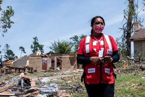 Red Cross volunteer surveying destroyed homes