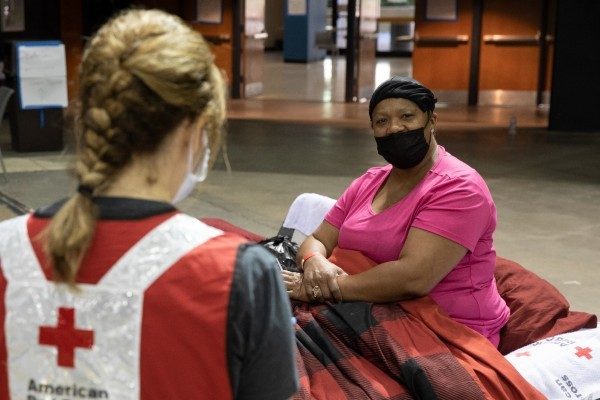 Woman staying in a Red Cross shelter speaks with a volunteer
