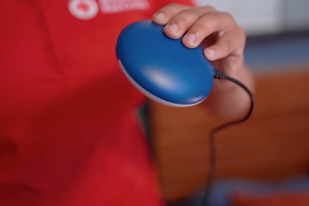 A Red Cross volunteer holds a bed shaker alarm