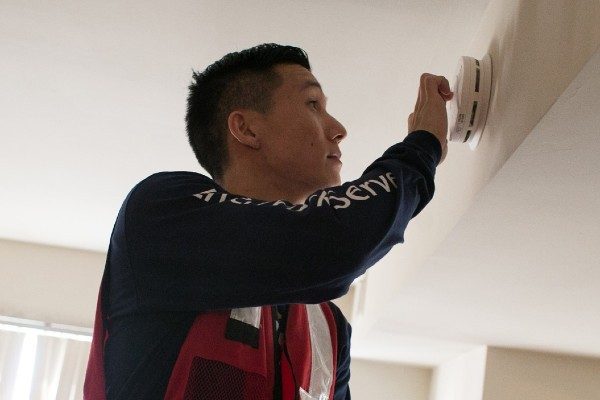 A Red Cross volunteer installs a smoke alarm