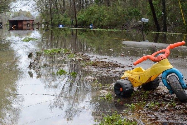 A child's toy waits in the mud after a flood