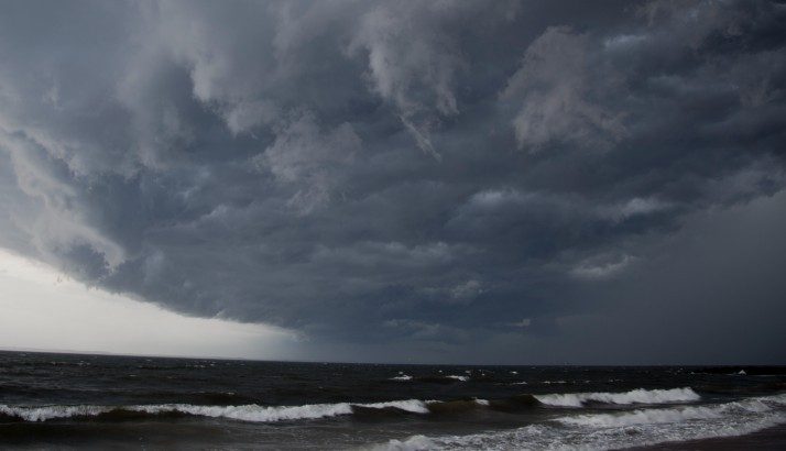 A grey stormcloud gathering over the ocean