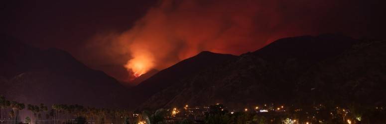 A wildfire in the hills outside of a town