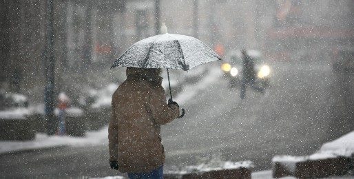 A person walks home through falling snow