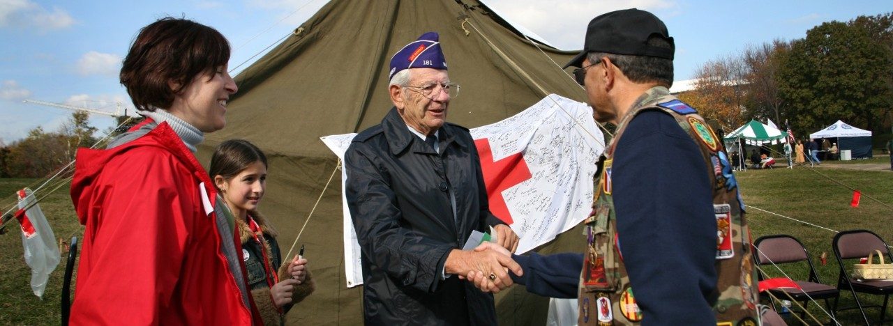 Military veteran signing American Red Cross flag