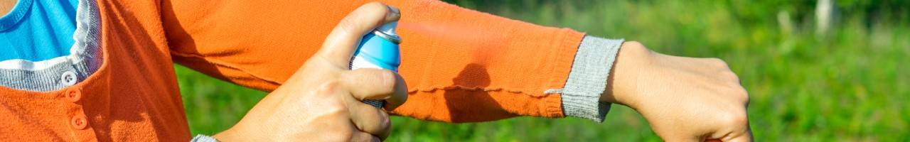 Person applying insect repellent to their arm