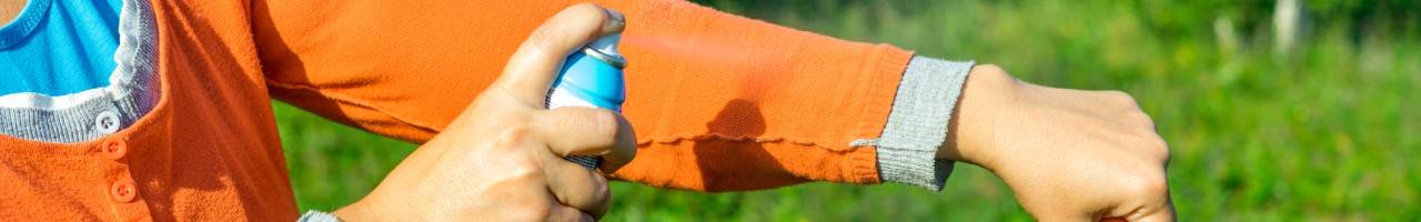 Person applying insect repellent to their arm 