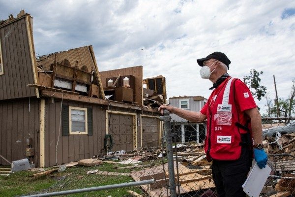 Red Cross volunteer visits a home damaged by a tornado