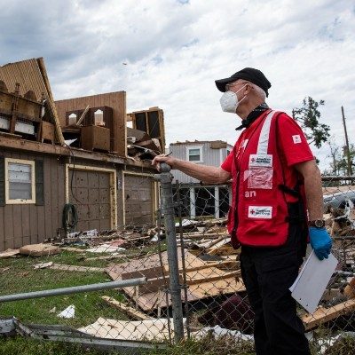 A Red Cross volunteer assesses damage to a home that was struck by a tornado