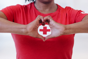 essay about health protocols for covid 19 Woman making a heart shape with her hands around Red Cross logo