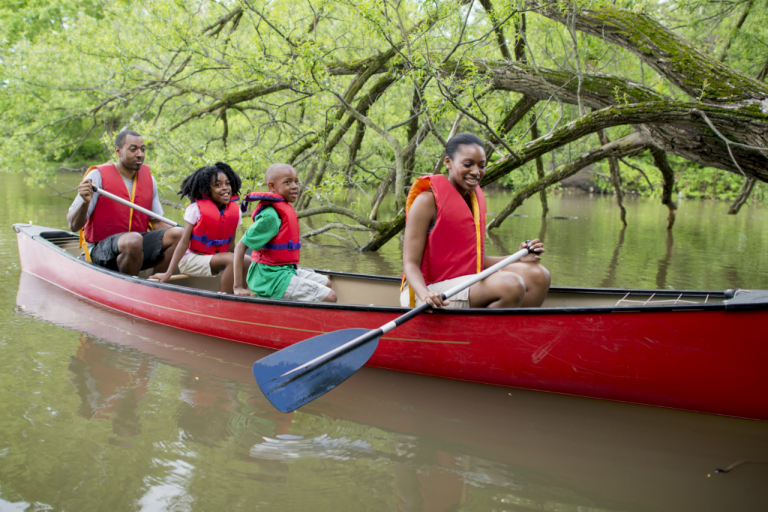 Family canoeing down river all wearing life jackets