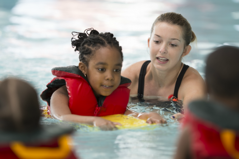 Boy wearing life jacket signaling o-k