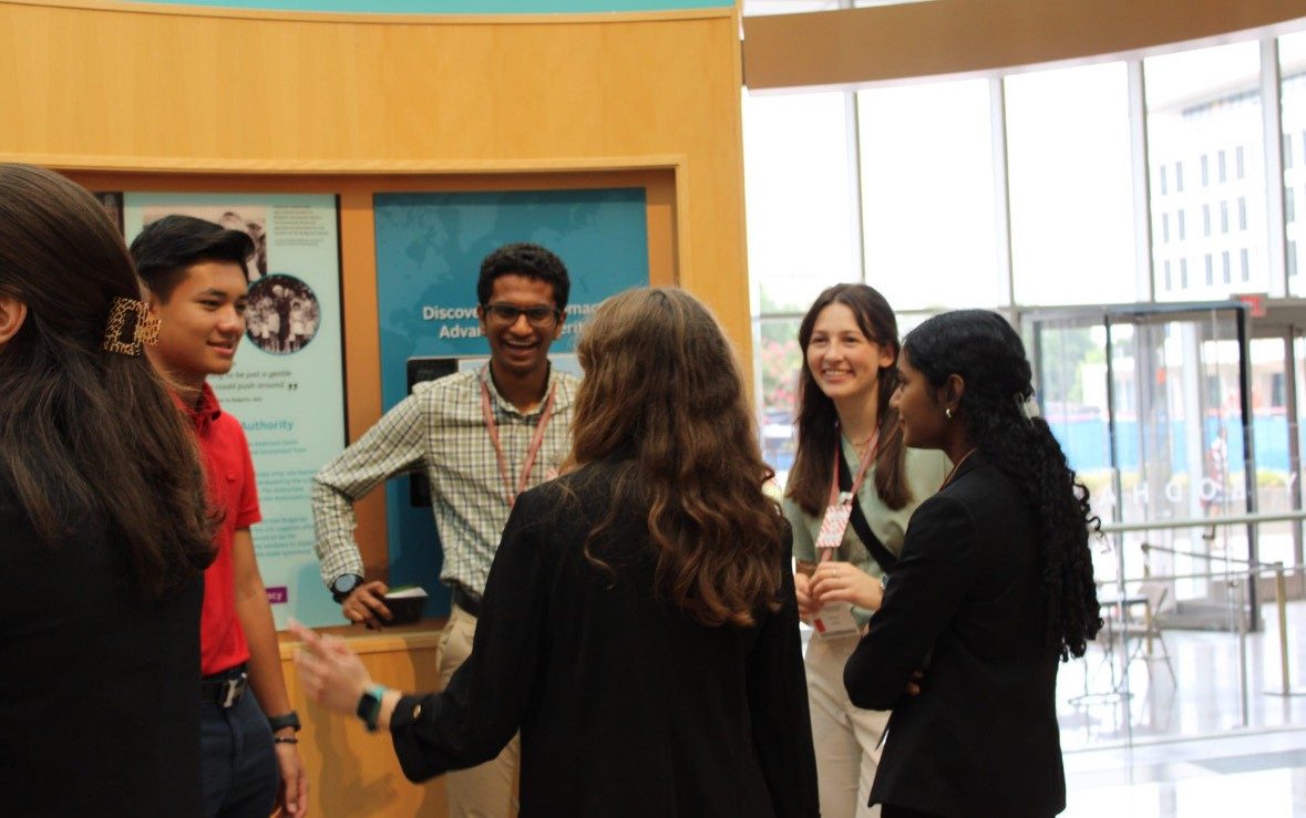 a diverse group of people standing in a circle and talking with smiles on their faces
