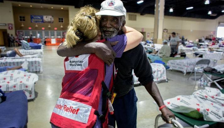 Volunteer hugs man in shelter