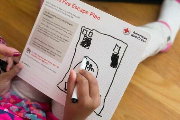 person writing on home fire escape plan sheet