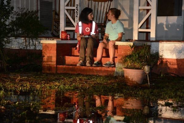 red cross volunteer sitting on porch with client