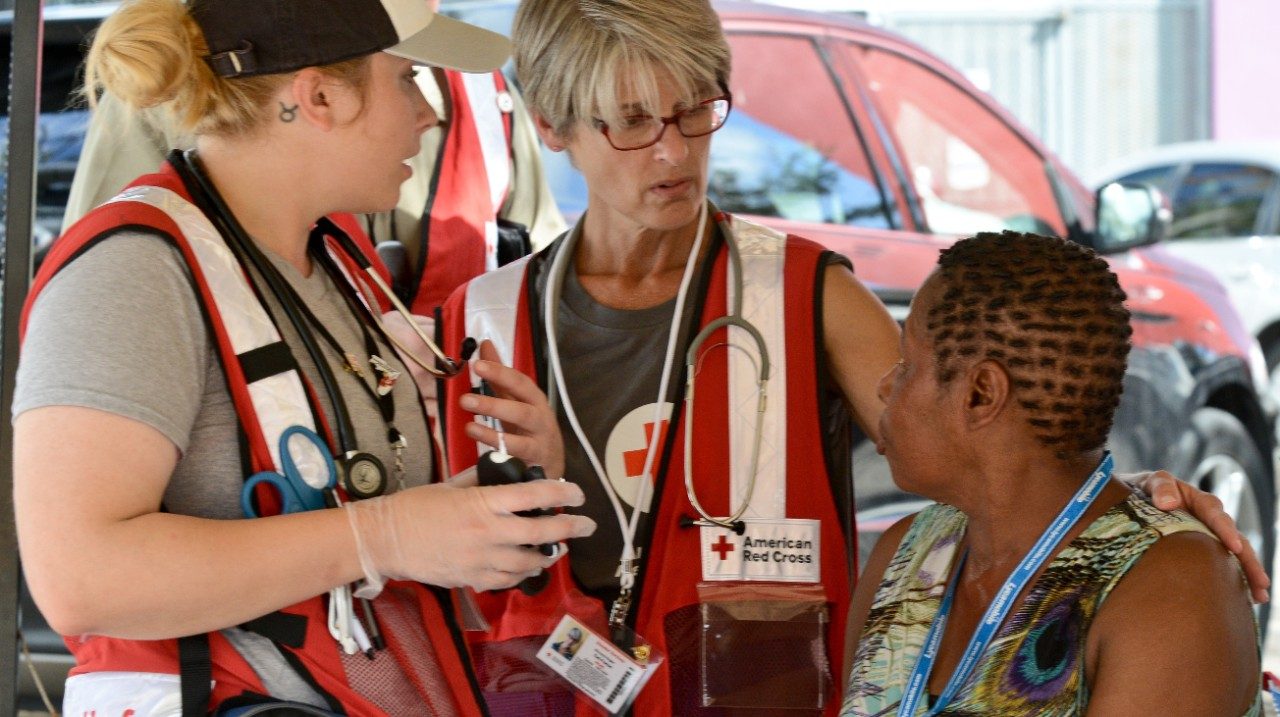 volunteers speaking with young woman