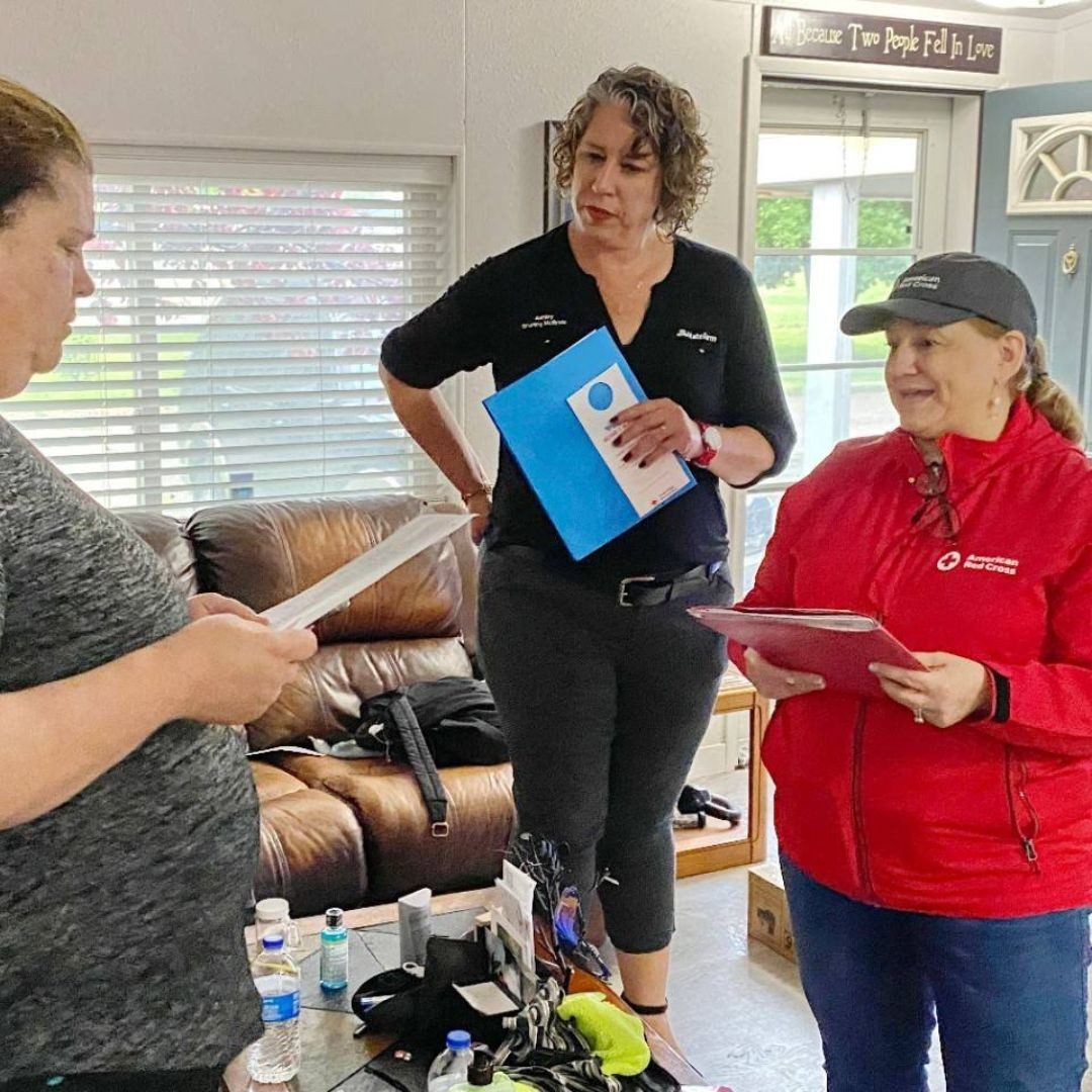 red cross volunteers speaking with resident